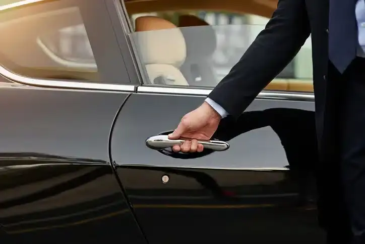 Chofer privado abriendo la puerta del auto a un paciente